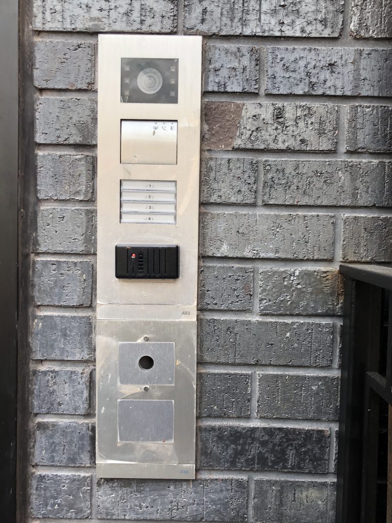 Close up view of ABB video intercom panel installed on an exterior brick wall