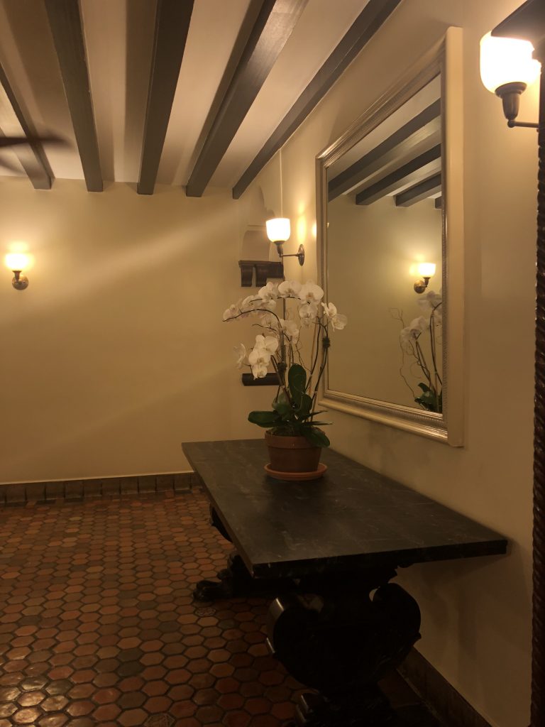 Building hallway with side table, plant and mirror
